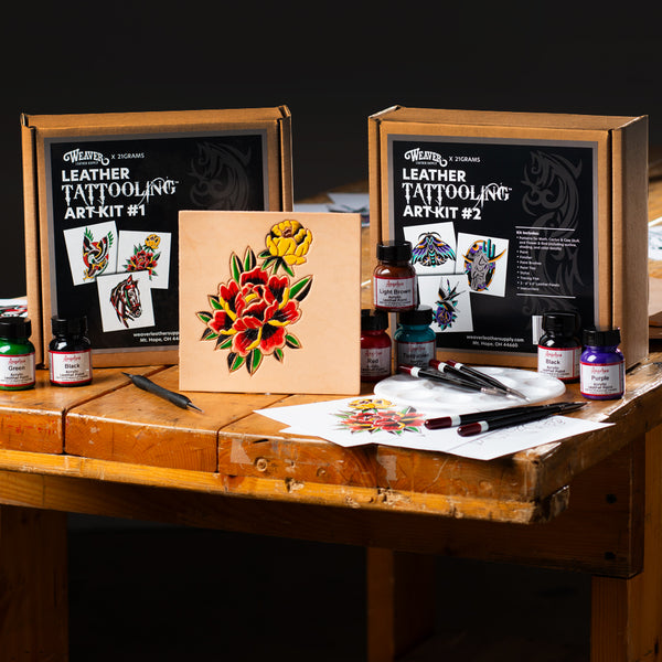 Weaver Leather Tattooing Art Kits with dyes, brushes, and a floral leather design displayed on a wooden table.