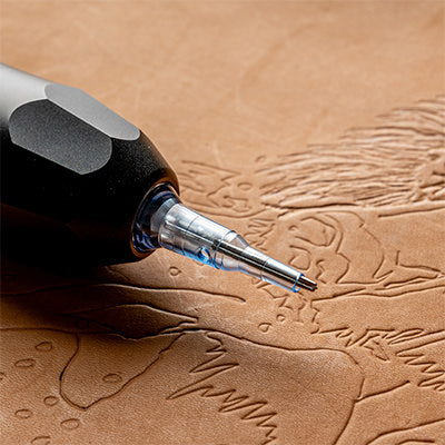 Close-up of a leather tattooling machine engraving a detailed design onto veg-tan leather.